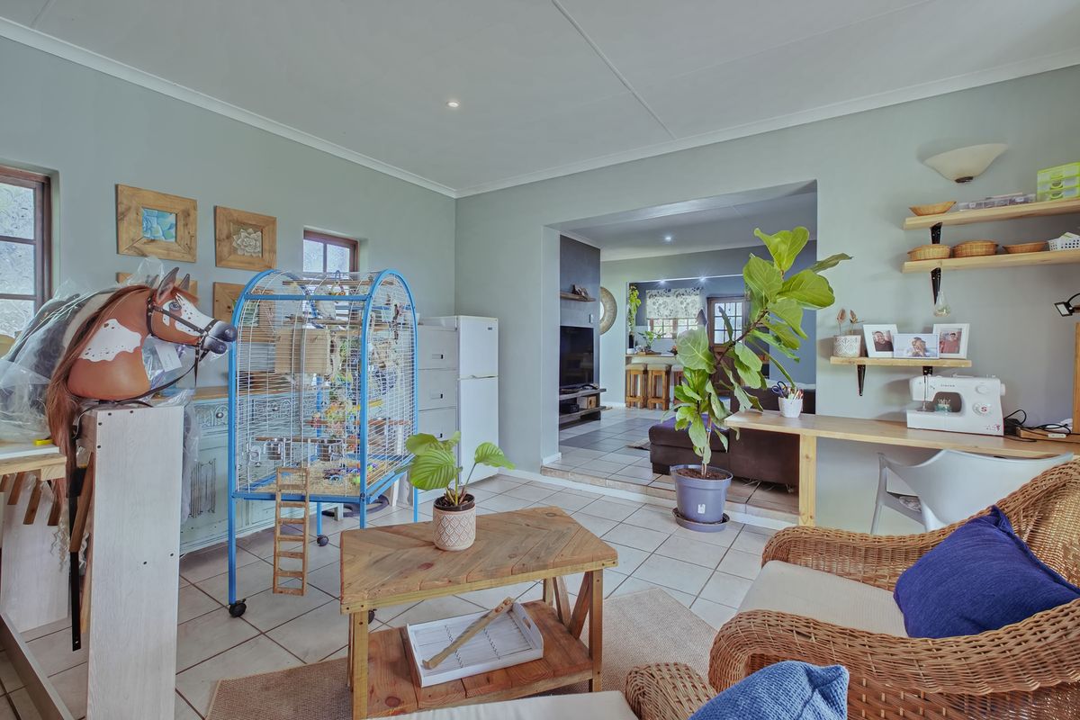 A living area featuring tiled flooring and recessed lighting, with an open-plan transition into an adjacent room.