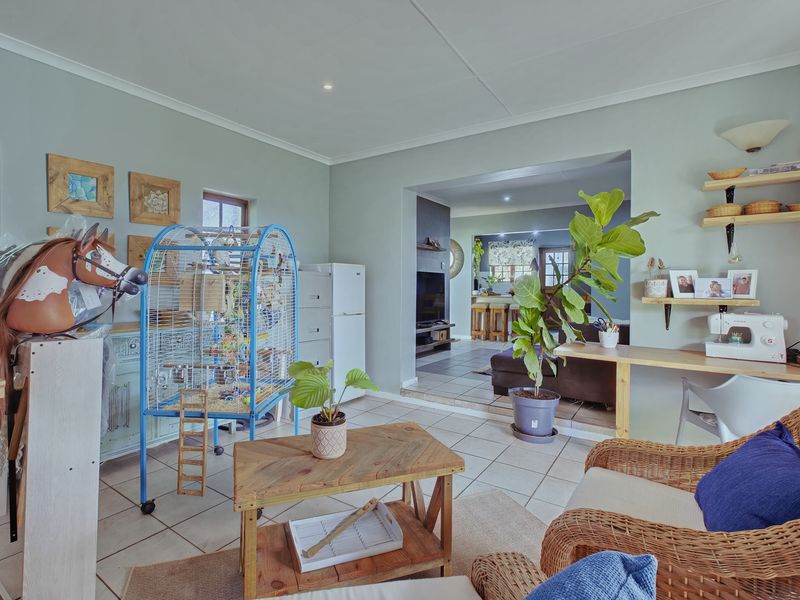 A living area featuring tiled flooring and recessed lighting, with an open-plan transition into an adjacent room.