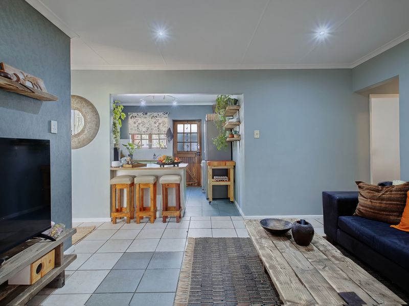 Open plan living area featuring tiled flooring, recessed lighting, and a breakfast bar connecting to the kitchen space.