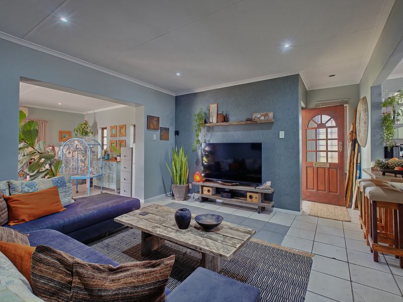 Open plan living area featuring ceramic tiled flooring, recessed downlighting, and a direct connection to the kitchen and entrance.
