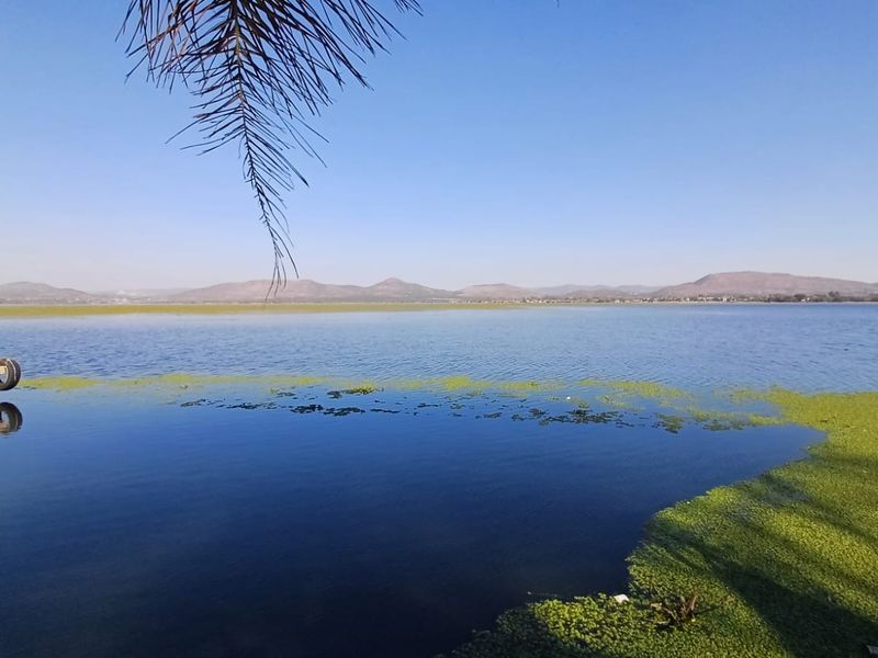A scenic view overlooking a large lake with distant mountains in the background.