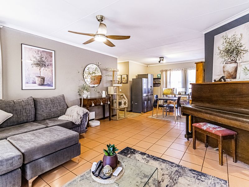 Open plan living and dining area featuring tiled flooring and a ceiling fan, providing a versatile space for relaxation and meals.