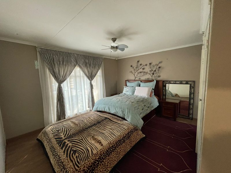 A standard bedroom featuring a ceiling fan and neutral wall tones, offering a functional space with potential for modern updates.