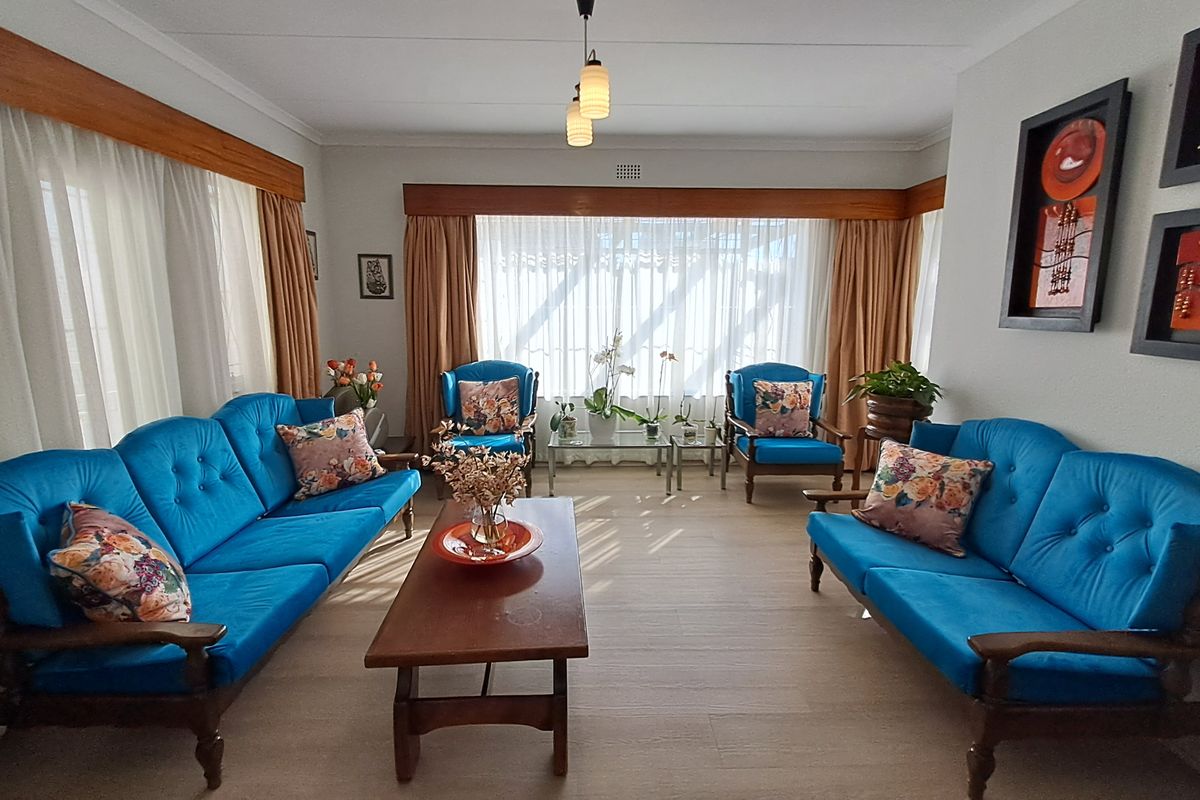 A well-lit living room featuring large windows with curtain rails and neutral flooring, offering a comfortable and functional space for relaxation.