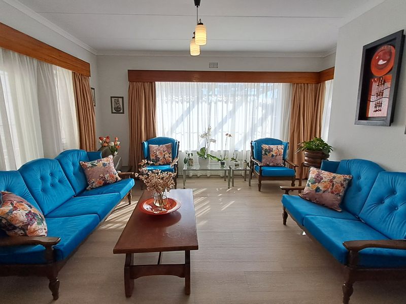 A well-lit living room featuring large windows with curtain rails and neutral flooring, offering a comfortable and functional space for relaxation.