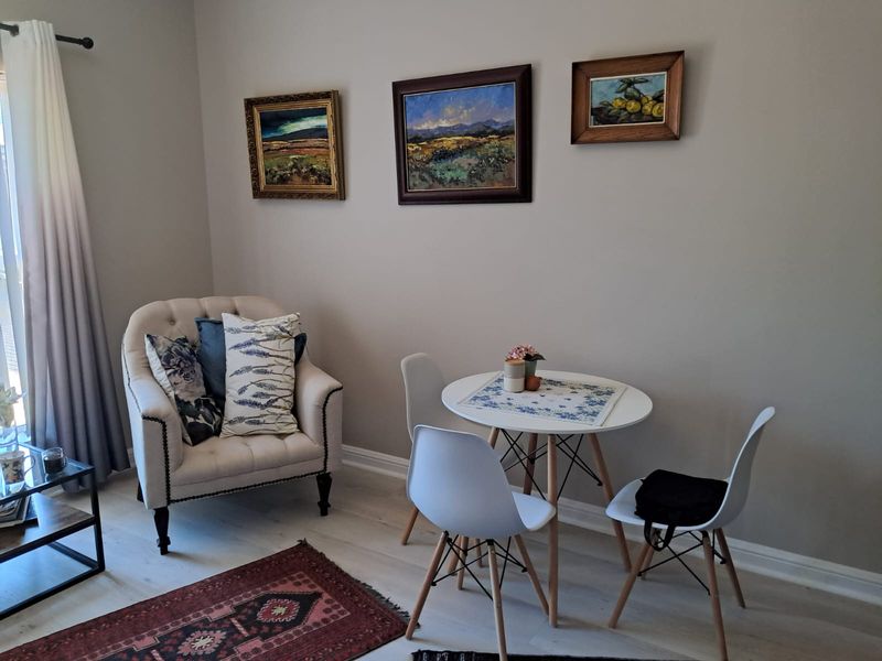 A bright and well-maintained living area featuring light-toned laminate flooring and neutral wall finishes, creating a comfortable and inviting space.