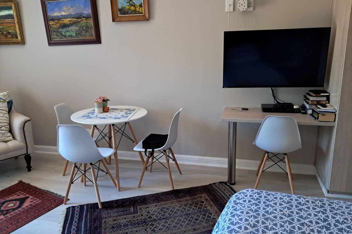 A well-maintained living area featuring a built-in desk, neutral wall finishes, and light-toned flooring, providing a functional and comfortable space.