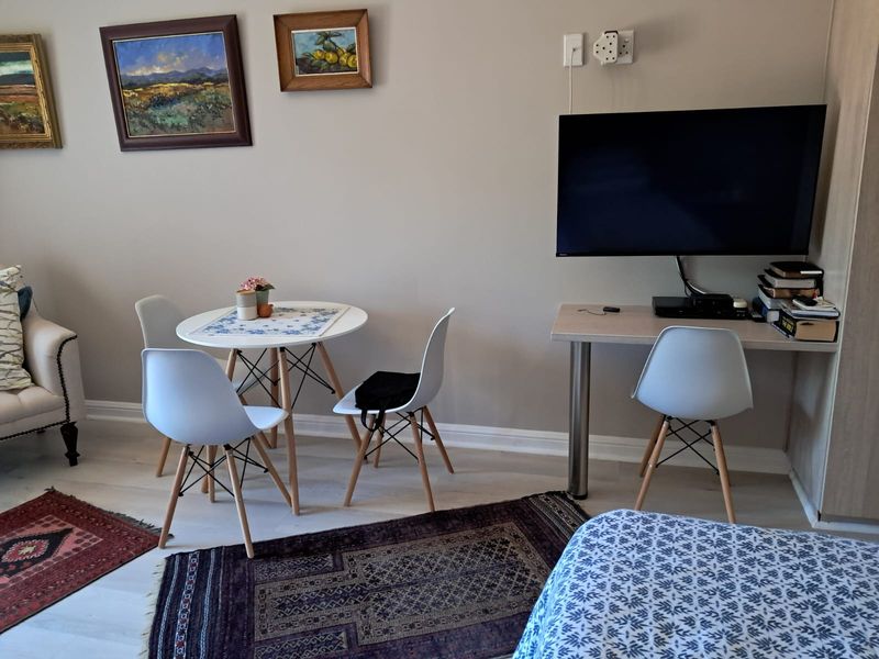 A well-maintained living area featuring a built-in desk, neutral wall finishes, and light-toned flooring, providing a functional and comfortable space.