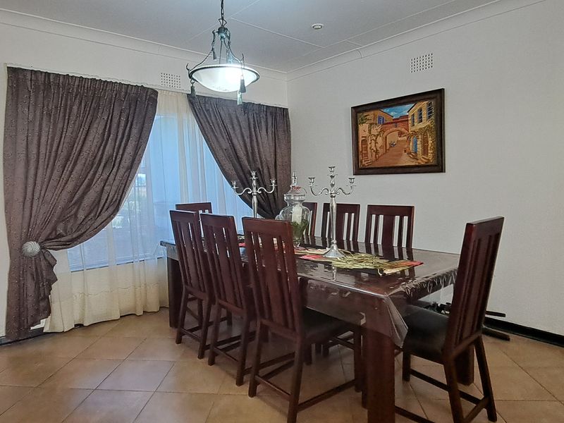 A dining room featuring tiled flooring and a central light fixture, providing a functional space for family meals and entertaining.