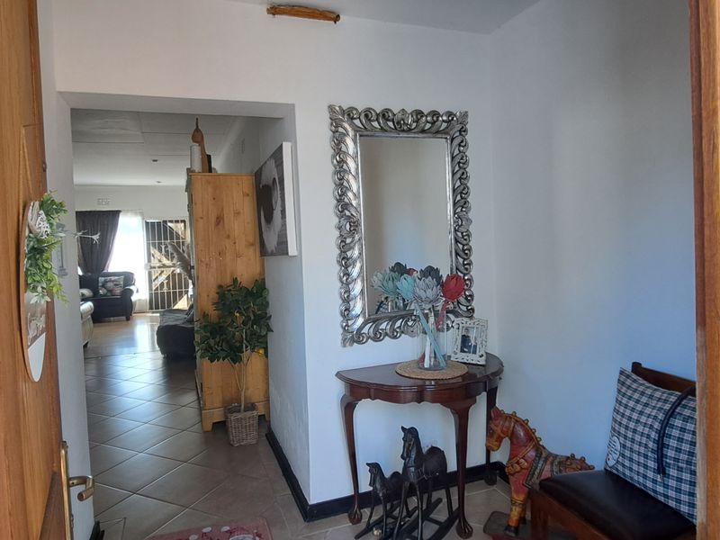 A welcoming entrance hall featuring tiled flooring and a solid wood front door, leading through to the main living area.