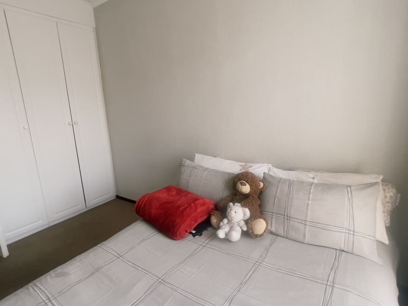 A bedroom featuring a built-in wardrobe with white doors and neutral wall finishes.