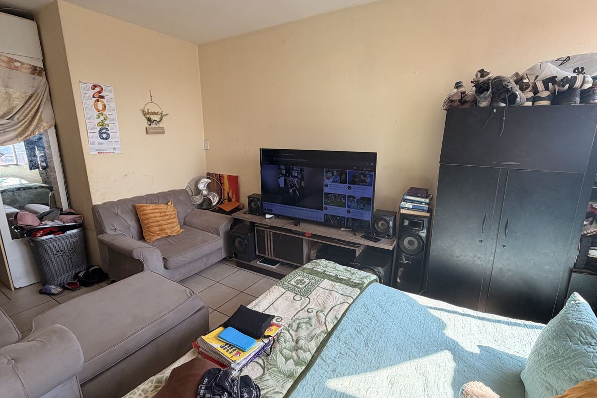A living room area featuring tiled flooring and neutral wall finishes, providing a functional space for relaxation and entertainment.