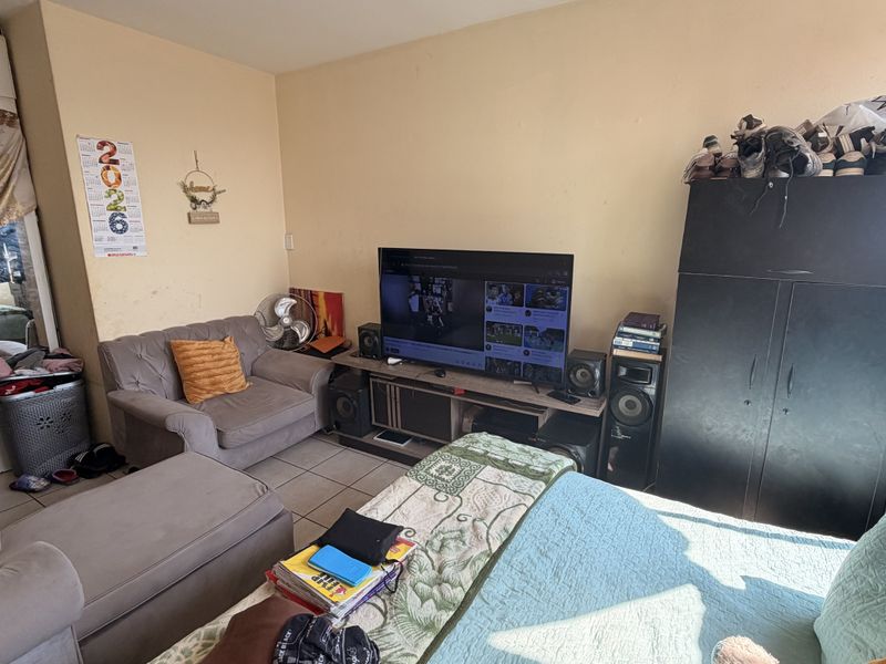 A living room area featuring tiled flooring and neutral wall finishes, providing a functional space for relaxation and entertainment.