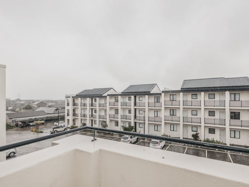 Elevated view from a balcony overlooking the apartment complex parking area and surrounding residential neighborhood.