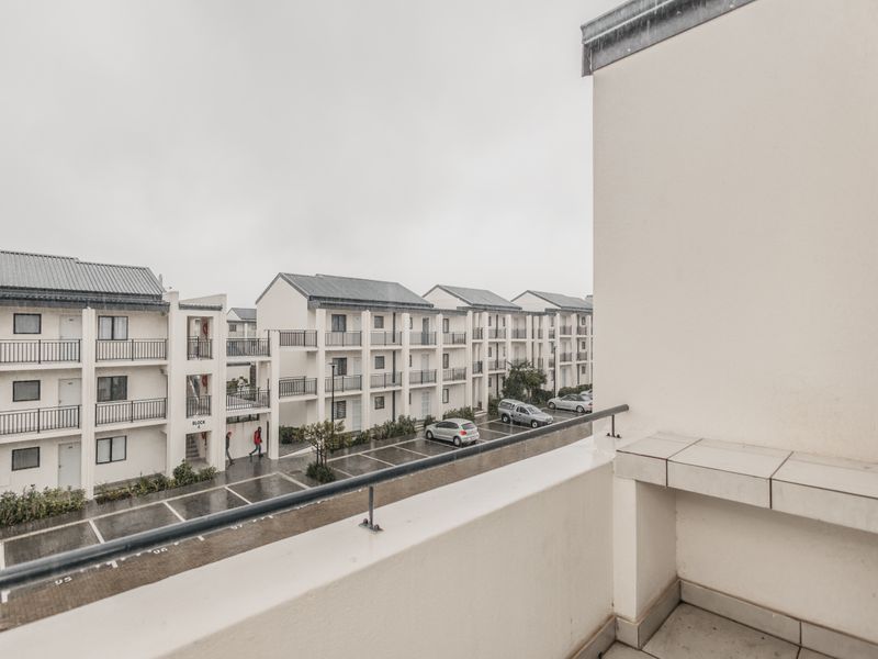 A private balcony overlooking the apartment complex parking area and adjacent residential blocks.