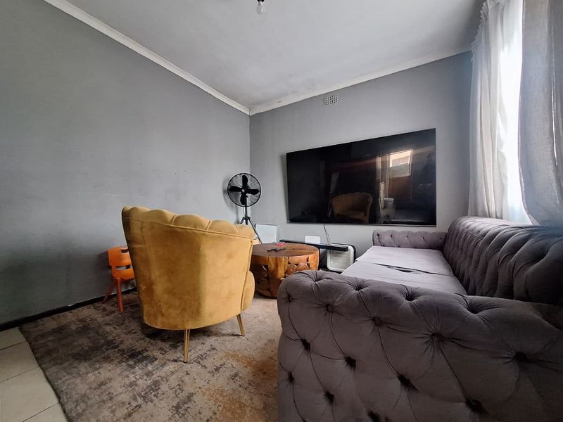 A living room featuring tiled flooring and coved ceilings, providing a functional space for relaxation.