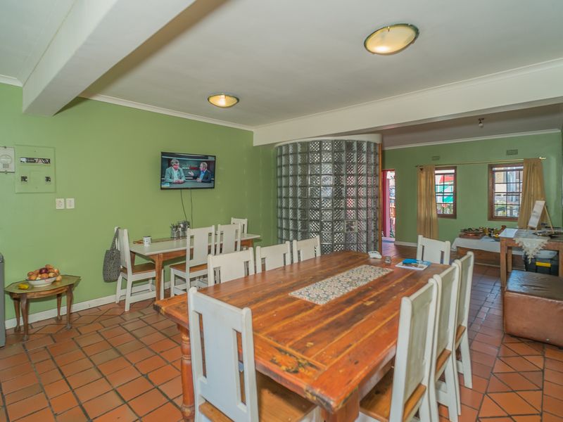 Spacious dining area featuring terracotta floor tiles and a distinctive glass block feature wall, offering a functional layout for family meals.