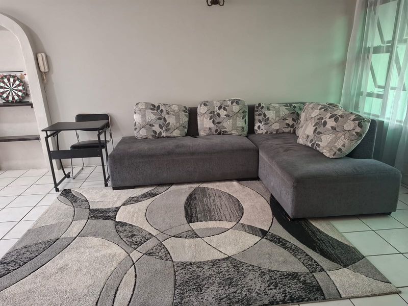 A living room area featuring neutral tiled flooring and a built-in arched wall niche, providing a functional space for relaxation.