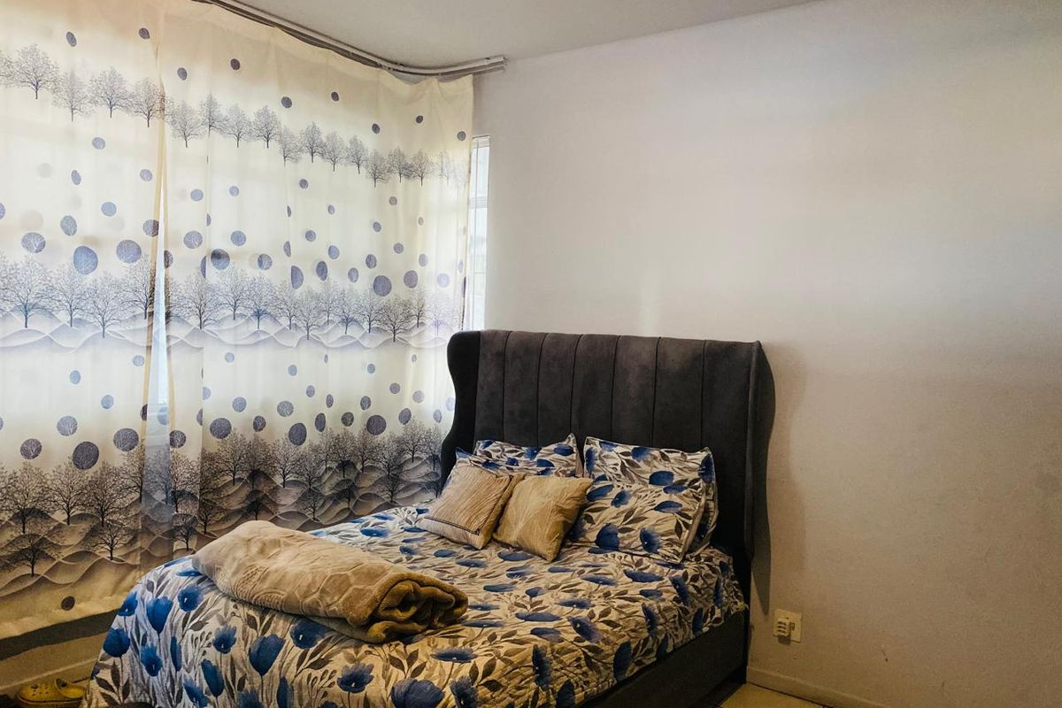 A bedroom featuring tiled flooring and a curtain track, providing a functional space for rest.
