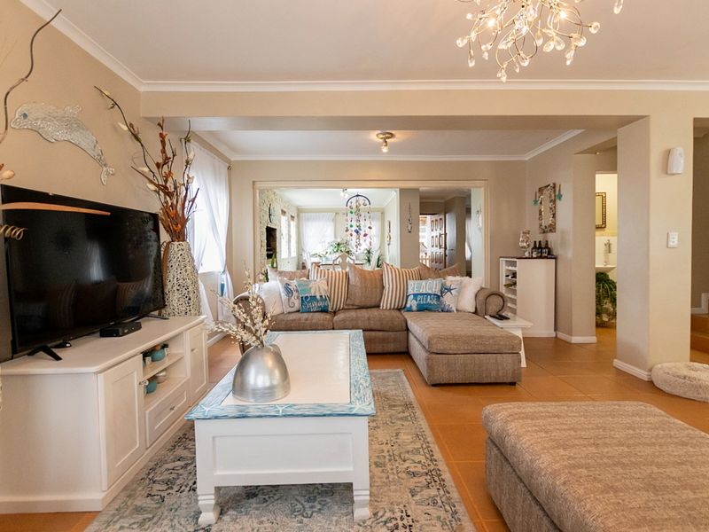 Spacious open-plan living area featuring tiled flooring, neutral wall tones, and a seamless flow into the adjacent dining space.