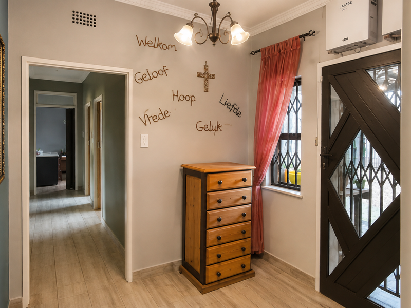 Welcoming entrance hall featuring tiled flooring, decorative ceiling cornice, and a secure entrance door with integrated security gate.