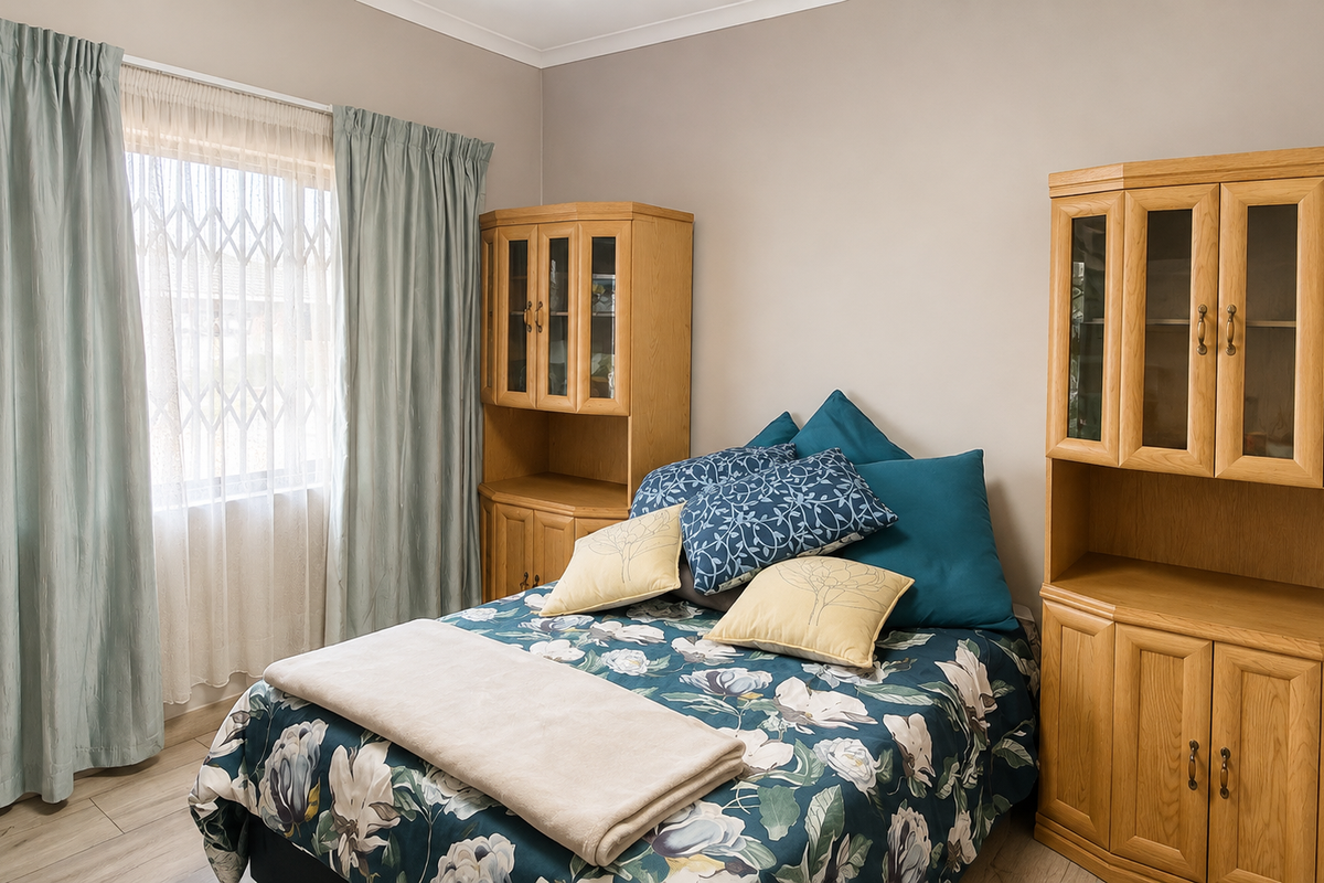A well-maintained bedroom featuring laminate flooring, neutral wall tones, and a window fitted with a security gate.