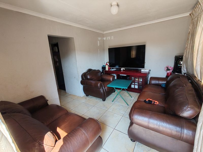 A living room featuring tiled flooring and neutral wall finishes, providing a functional space for relaxation.