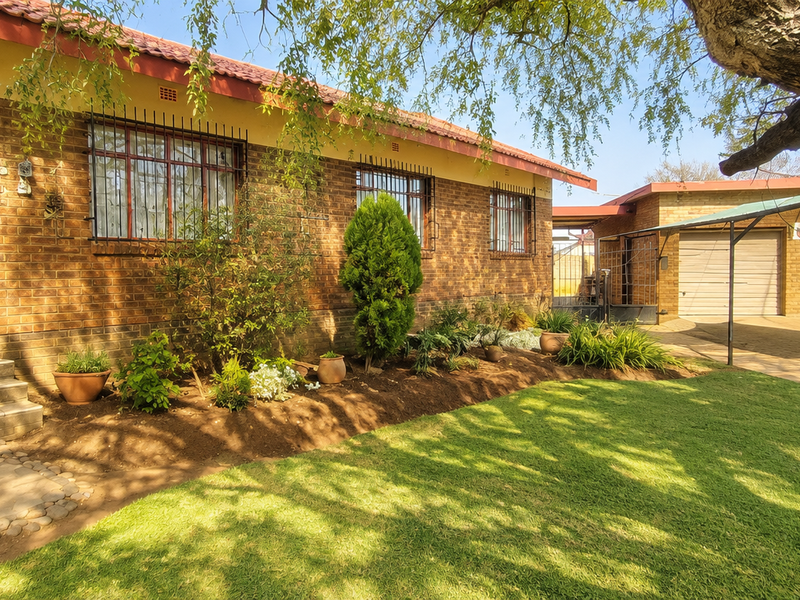 Front view of a facebrick house featuring a landscaped garden, paved driveway, double garage, and secure entrance with security gates.