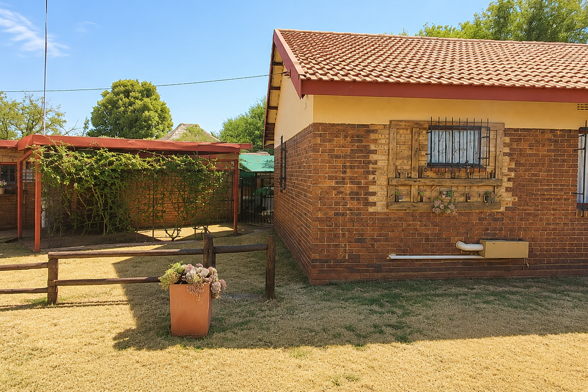 Rear view of the house featuring face brick exterior, tiled roof, security bars on windows, and a timber pergola structure in the garden.