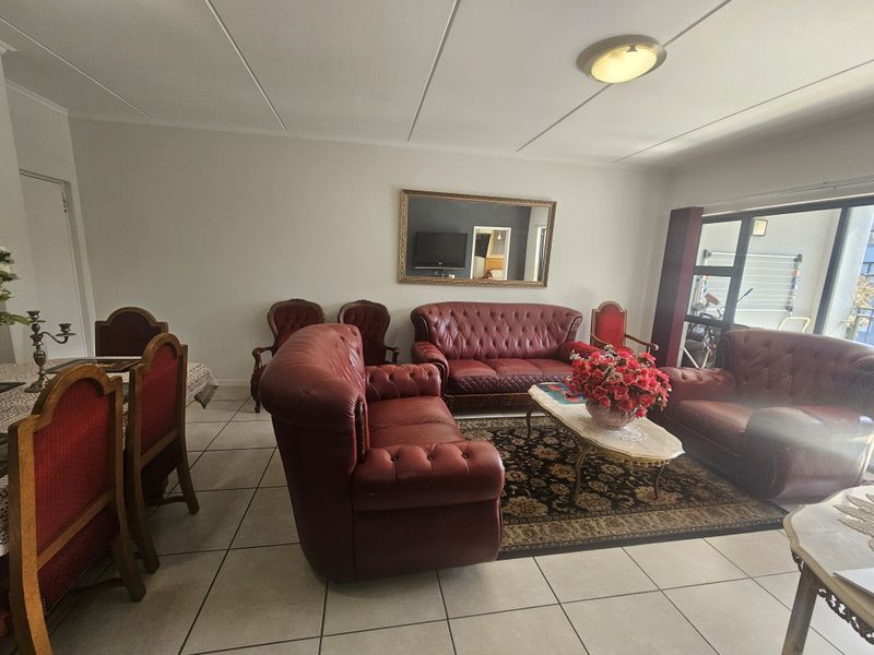 Spacious open-plan living and dining area featuring neutral tiled flooring and large sliding glass doors providing access to the outdoor space.
