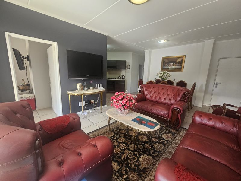 Spacious open-plan living and dining area featuring tiled flooring, neutral wall finishes, and direct access to the adjoining kitchen space.