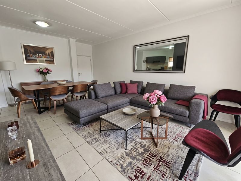 A spacious open-plan living and dining area featuring neutral tiled flooring and a bright, well-maintained interior layout.