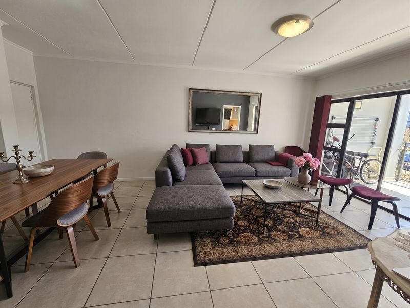 Open plan living and dining area featuring neutral tiled flooring and large sliding glass doors providing access to the outdoor space.