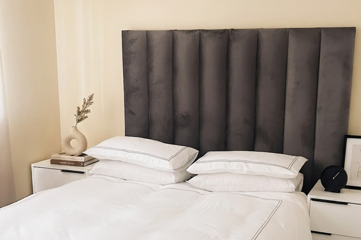 A well-maintained bedroom featuring neutral wall finishes, tiled flooring, and decorative coving.