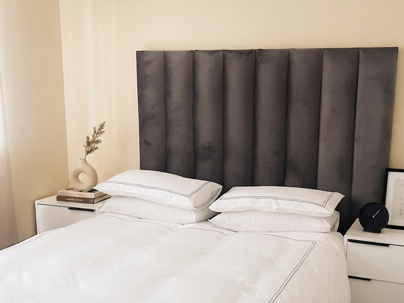 A well-maintained bedroom featuring neutral wall finishes, tiled flooring, and decorative coving.