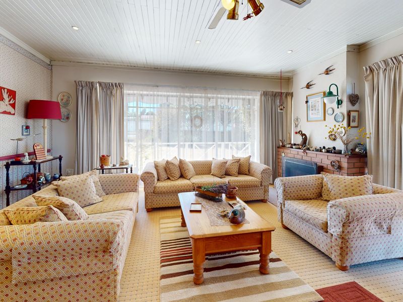 Spacious living room featuring a brick fireplace, tongue and groove ceiling, and large sliding glass doors providing access to the outdoor area.