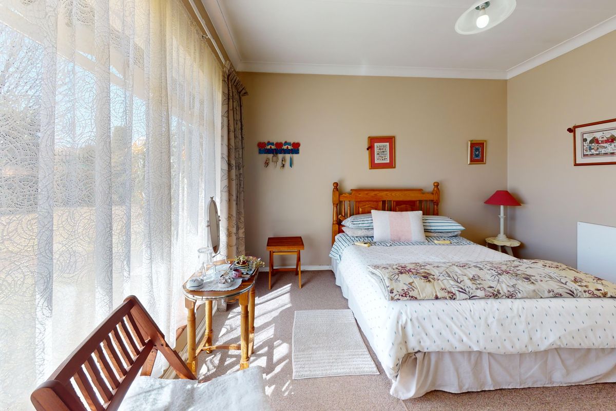 A well-lit bedroom featuring large sliding glass doors that provide ample natural light and direct access to the outdoors.