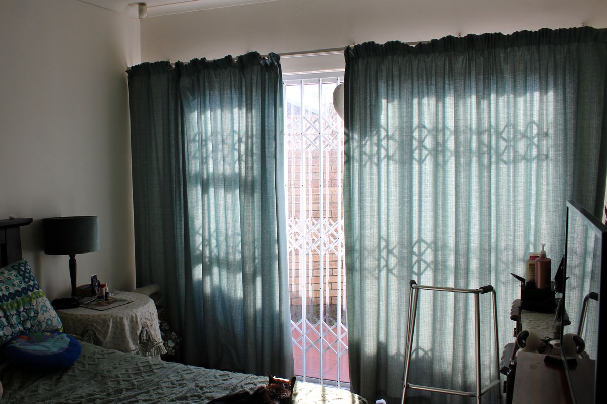 Bedroom featuring a sliding glass door with a security gate, providing access to the exterior.