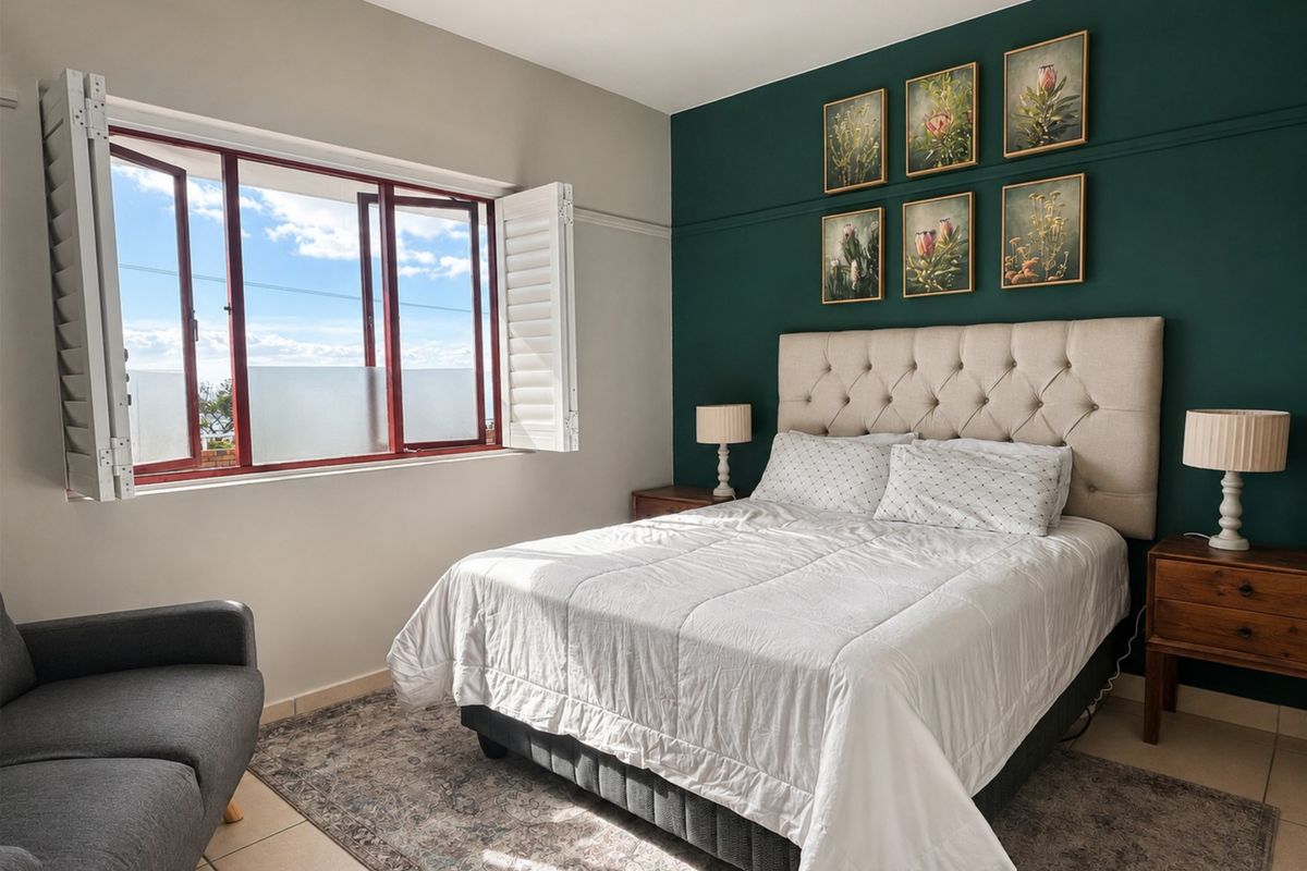 A well-maintained bedroom featuring tiled flooring, a decorative picture rail, and functional plantation shutters on the window.