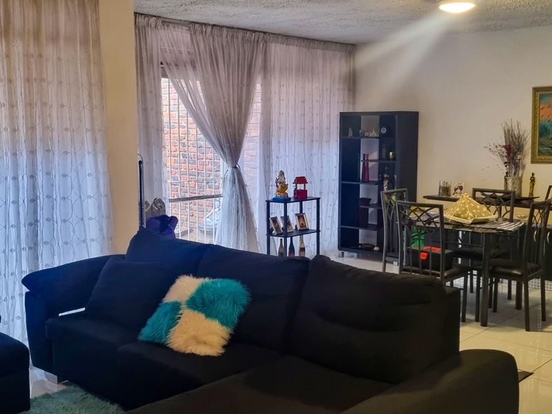 Open plan living and dining area featuring tiled flooring and large sliding glass doors providing access to the exterior.