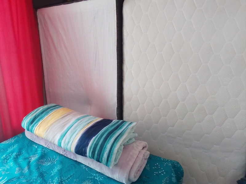 A close-up view of a bedroom space featuring a mattress and bedding.