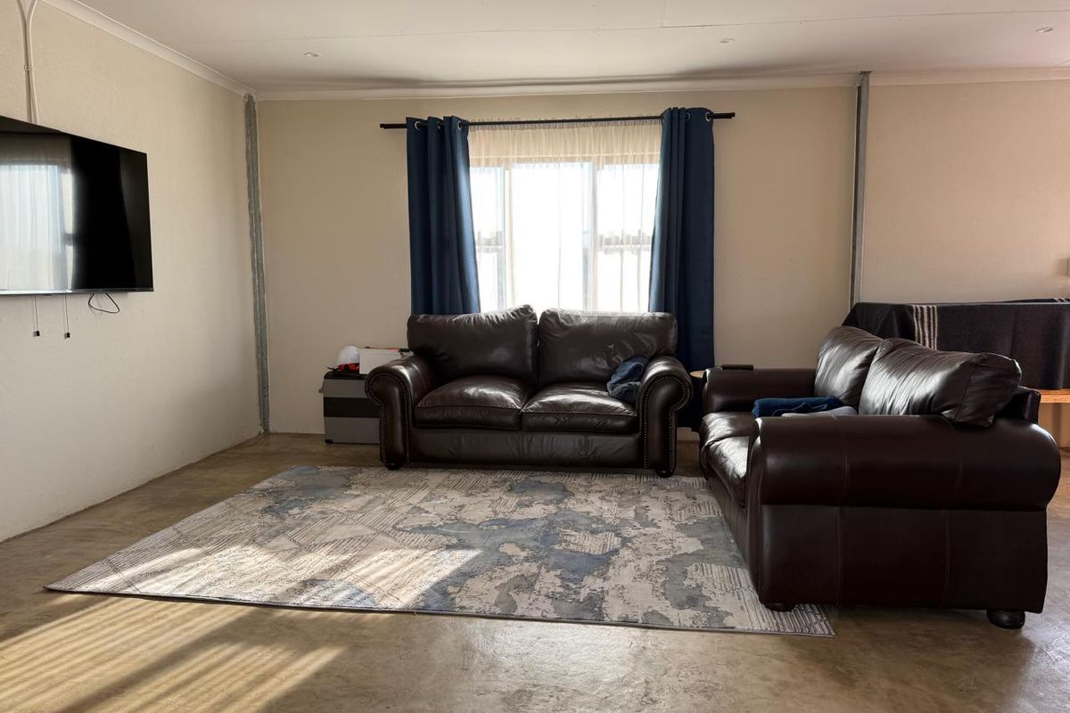 A living room area featuring concrete flooring and exposed wall corner beading, offering a blank canvas for potential interior upgrades and finishes.