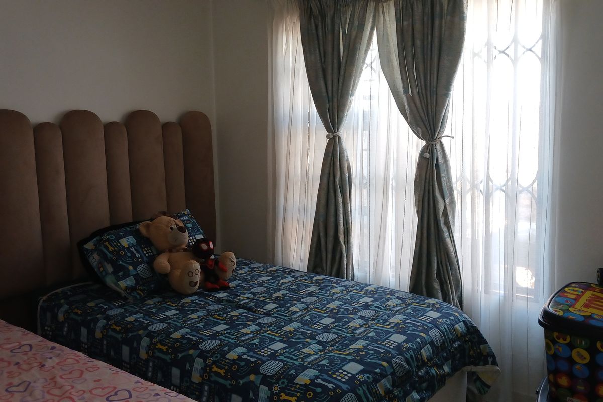 A bedroom featuring a window with an integrated security gate, providing natural light and essential security features.