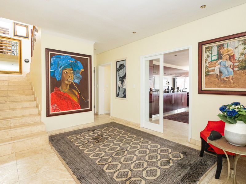 Spacious entrance hall featuring stone flooring, a stone staircase, and a sliding glass door leading to an adjacent living area.