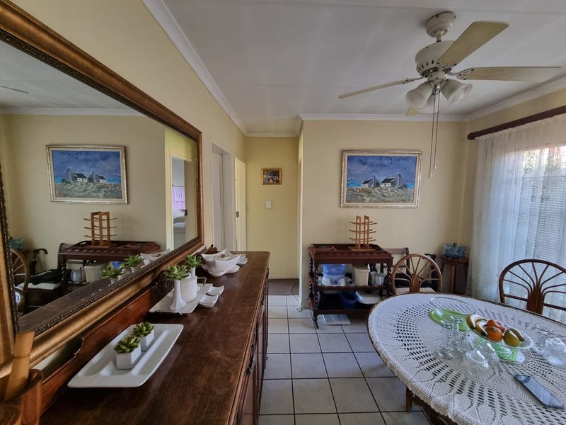 A dining area featuring tiled flooring, a ceiling fan, and coved ceiling details, providing a functional space for meals.