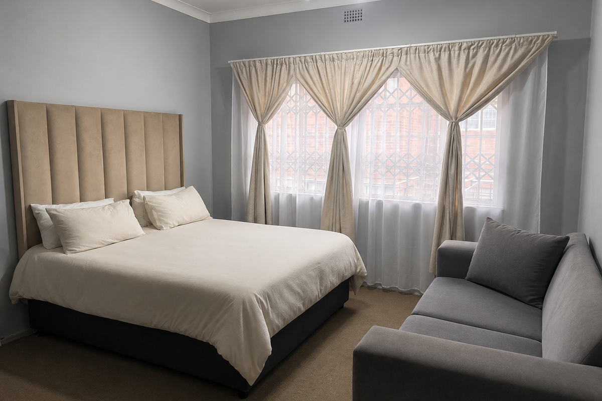 A well-maintained bedroom featuring neutral wall tones, carpeted flooring, and a window fitted with a security gate.