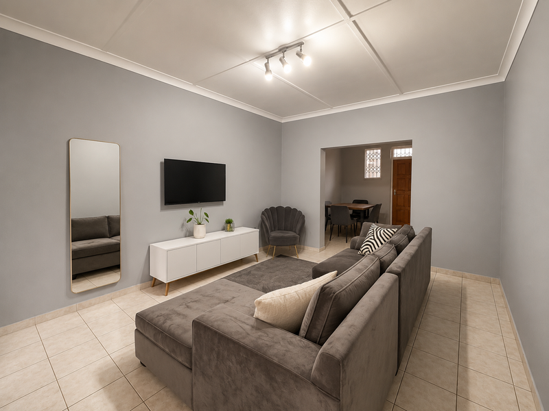 A well-maintained living room featuring neutral grey walls, tiled flooring, and a modern ceiling panel design with integrated track lighting.
