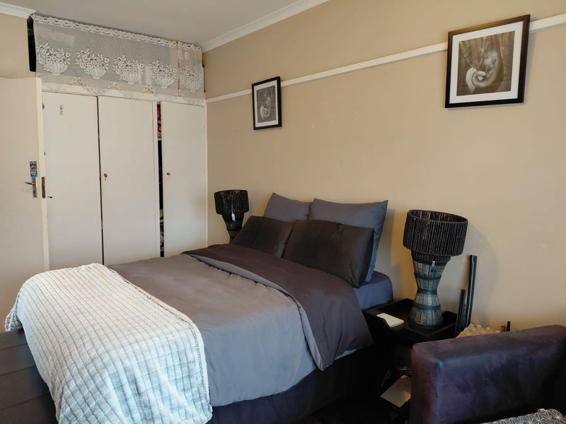 A bedroom featuring built-in cupboards and a classic picture rail, offering a functional space with neutral wall tones.