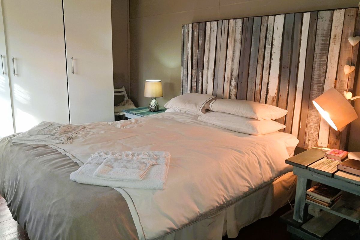 A cozy bedroom featuring a built-in wardrobe and a rustic-style headboard, creating a warm and inviting atmosphere.
