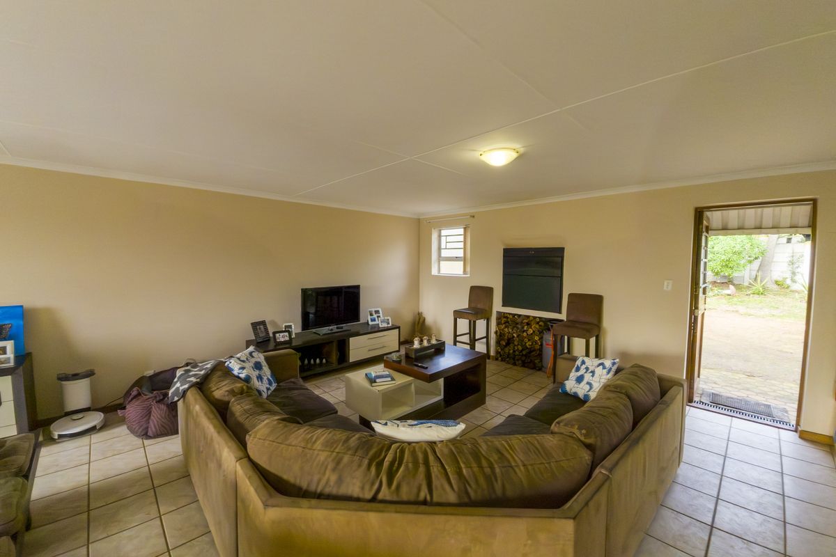 A spacious living room featuring tiled flooring and direct access to the outdoor area, providing a functional and open layout.